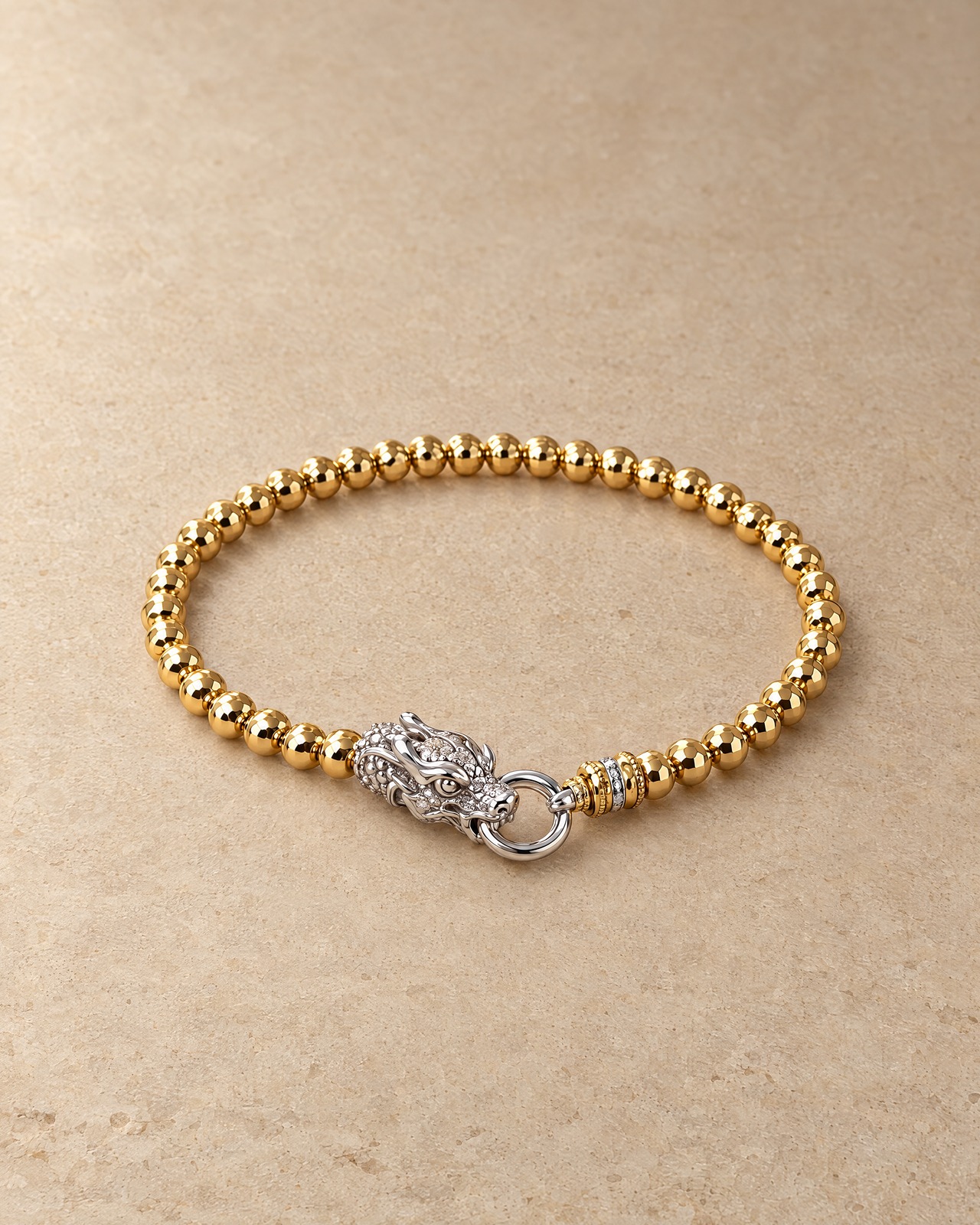 The gold-tone beaded dragon bracelet in a still-life photograph