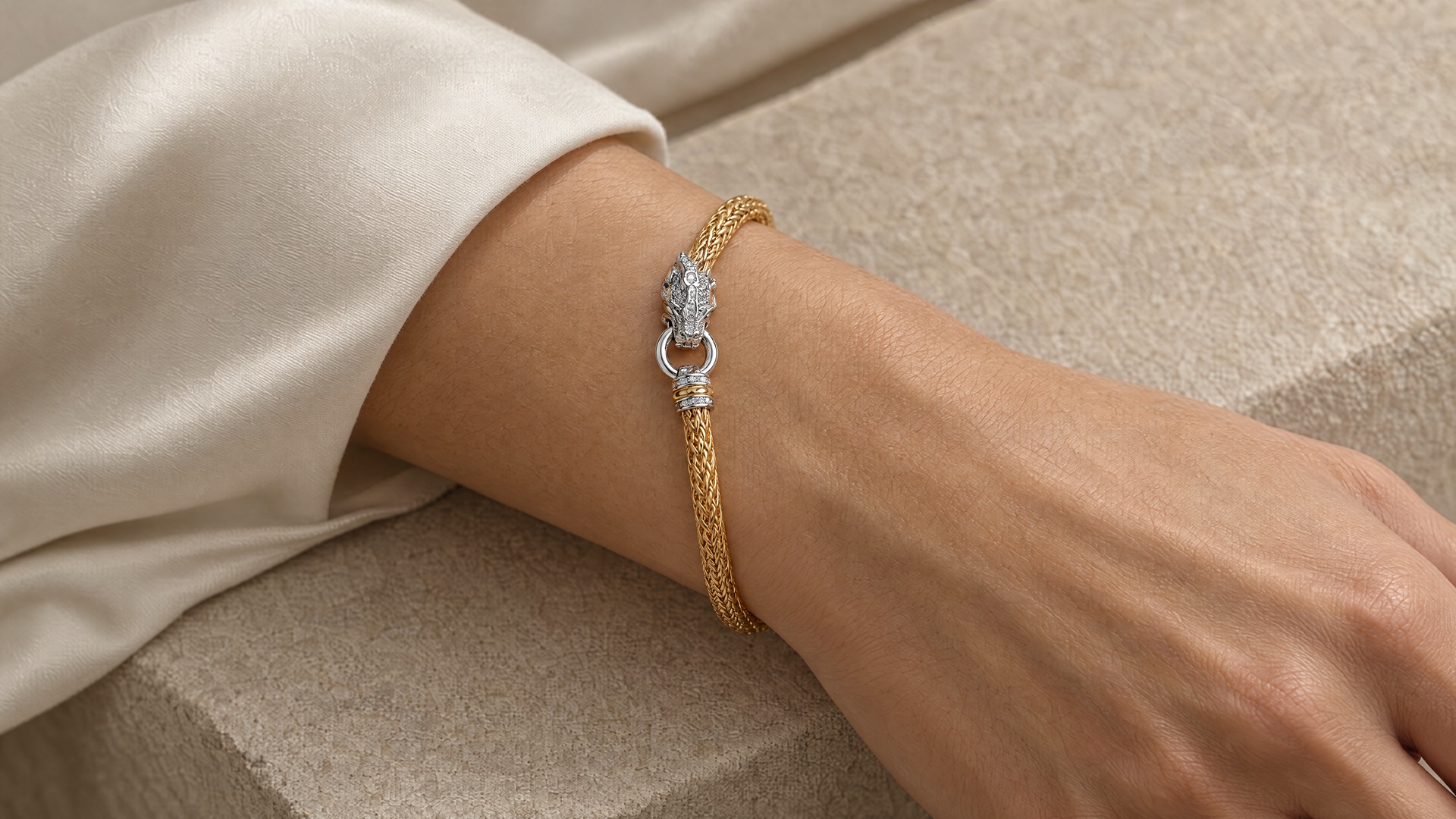 The gold-tone woven dragon bracelet worn on a wrist
