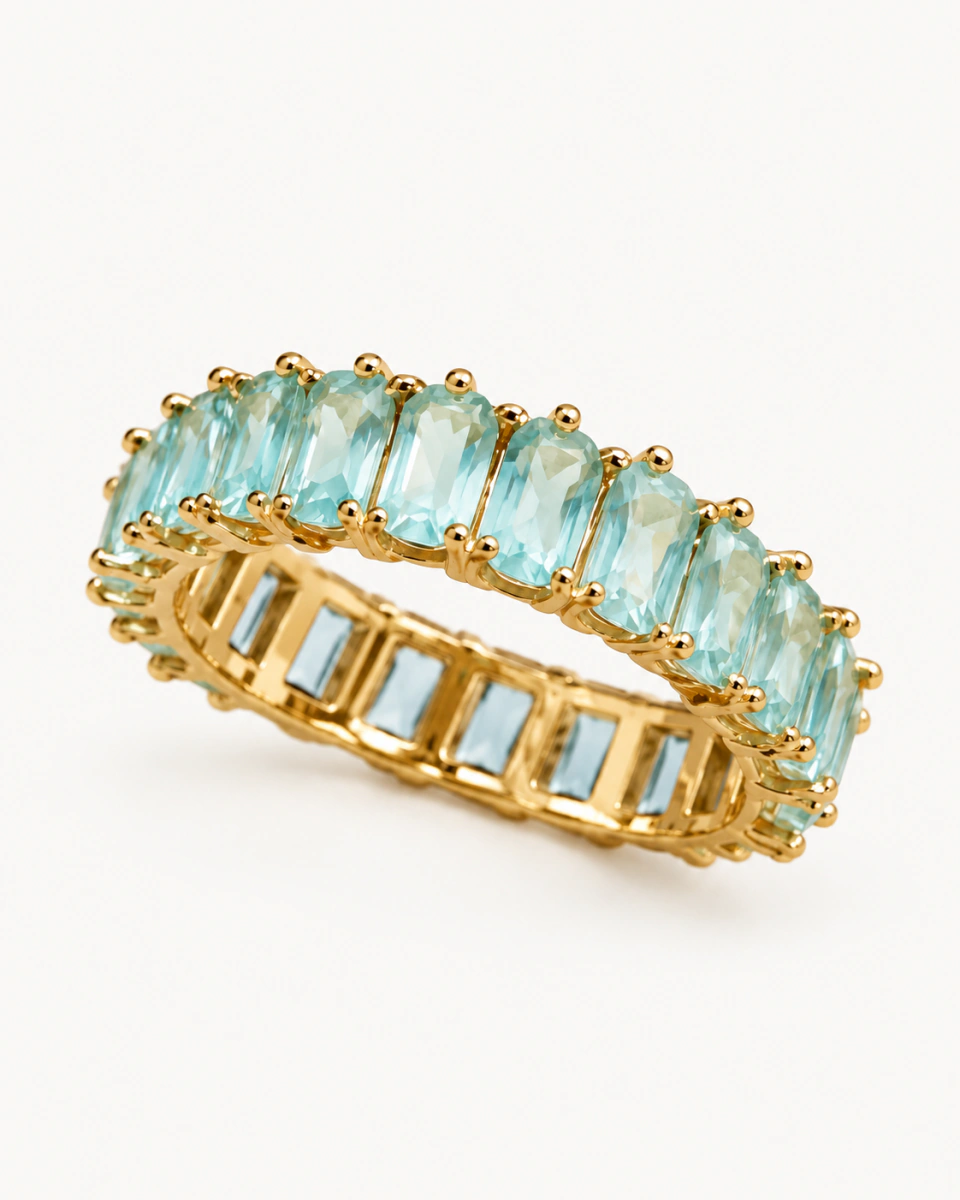 The aqua ring with pale blue-green rectangular stones and small gold-tone prongs, on a light background