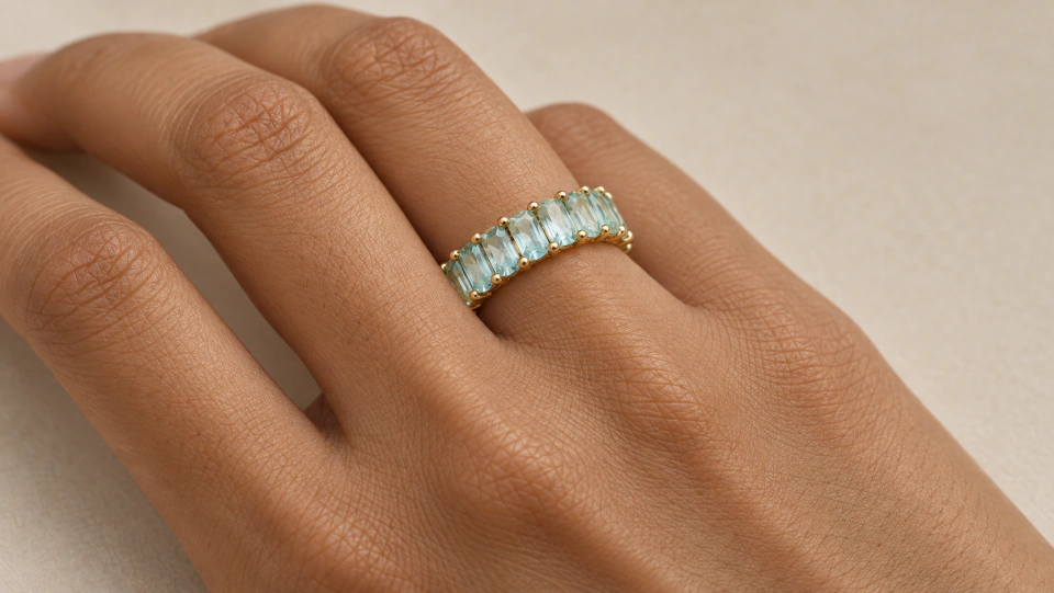 The aqua ring worn on a finger in a close view of the hand
