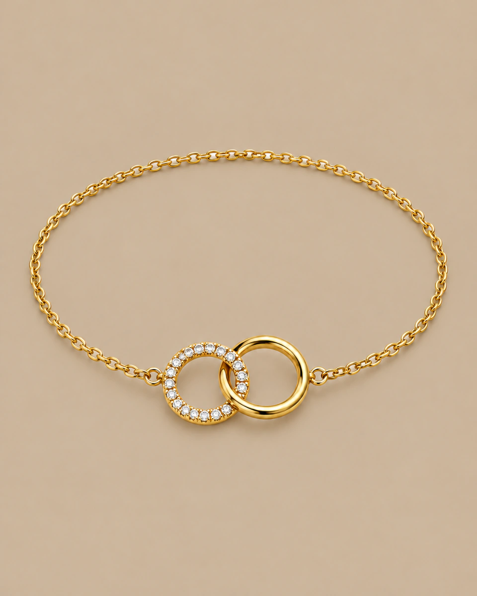 The gold-tone circle bracelet with its fine chain and two circles, on a warm beige background
