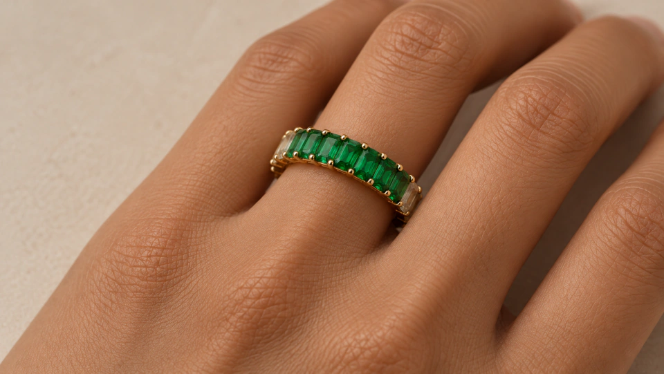 The green ring worn on a finger with its pale side details visible