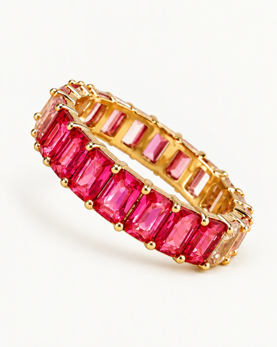 The pink ring with vivid pink rectangular stones and small gold-tone prongs, on a light background