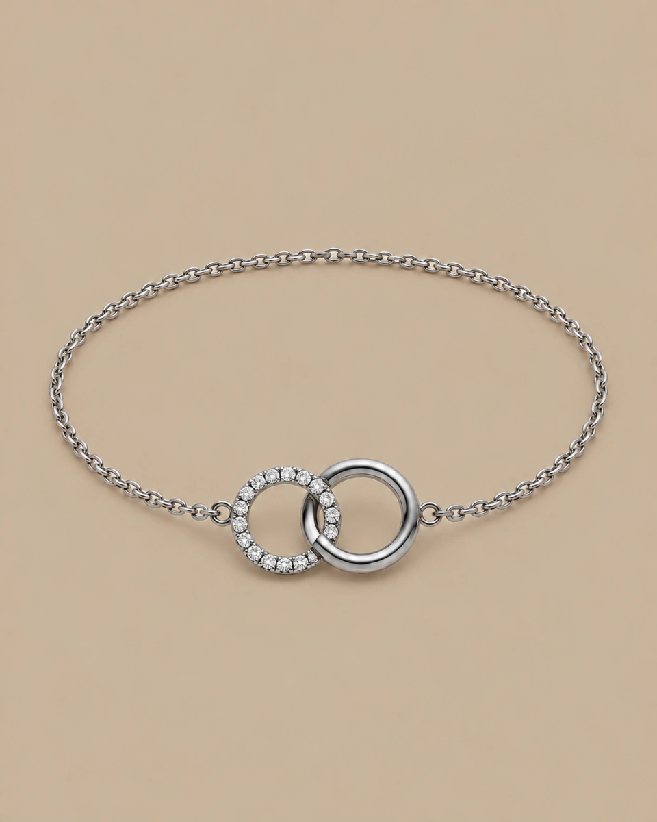 The silver-tone circle bracelet with its fine chain and two circles, on a warm beige background