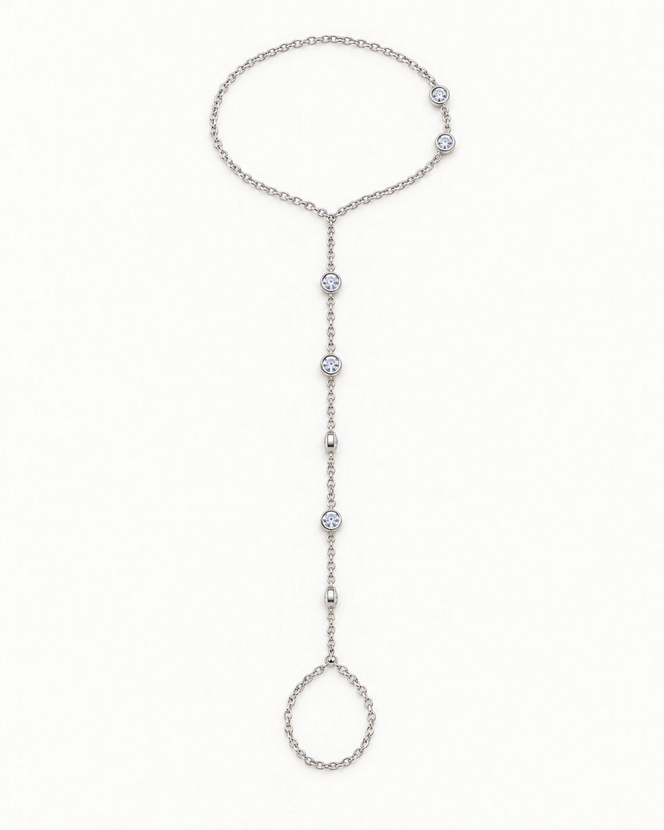 The silver-tone hand chain with finger and wrist loops and small clear-stone details, on a light background