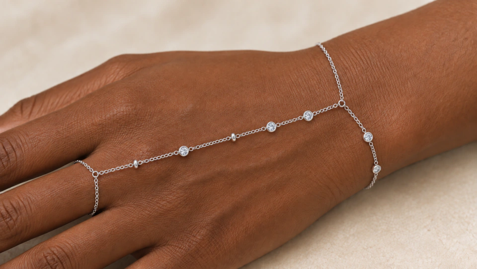 The silver-tone hand chain worn across the hand between finger and wrist